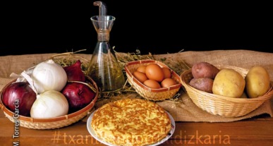 Patata-tortilla bere osagaiez inguratuta, arrautza, olioa, patatak eta tipula.